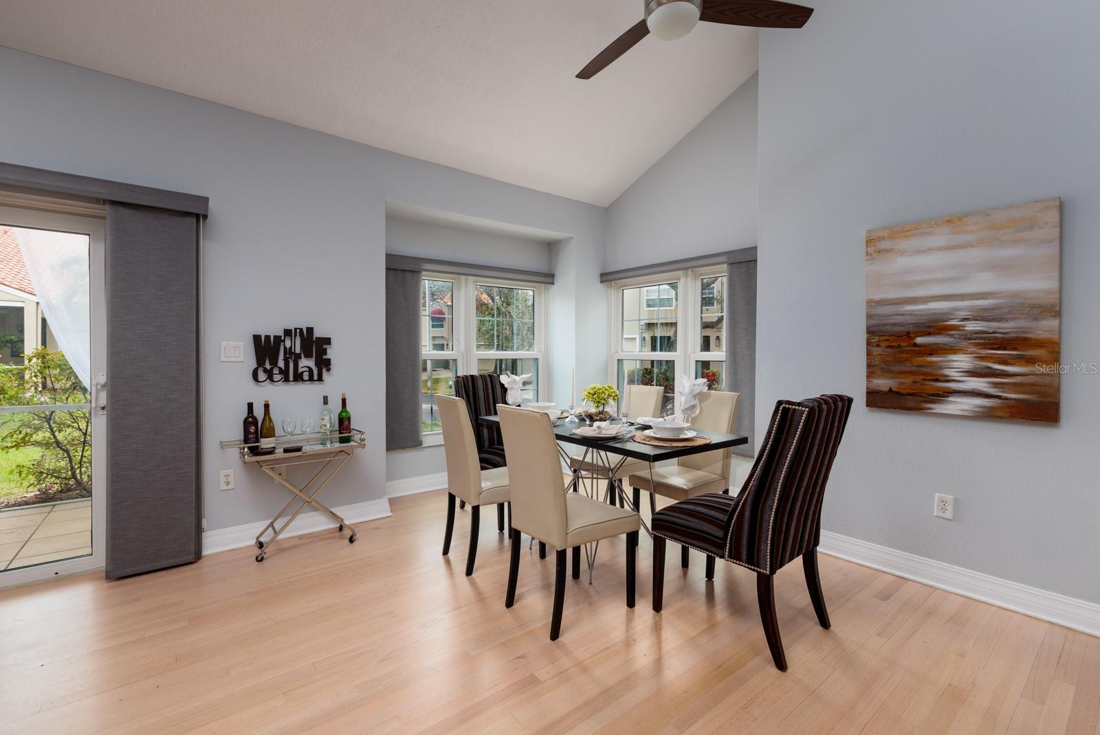 Dining area with light filtering blinds and hardwood floors.