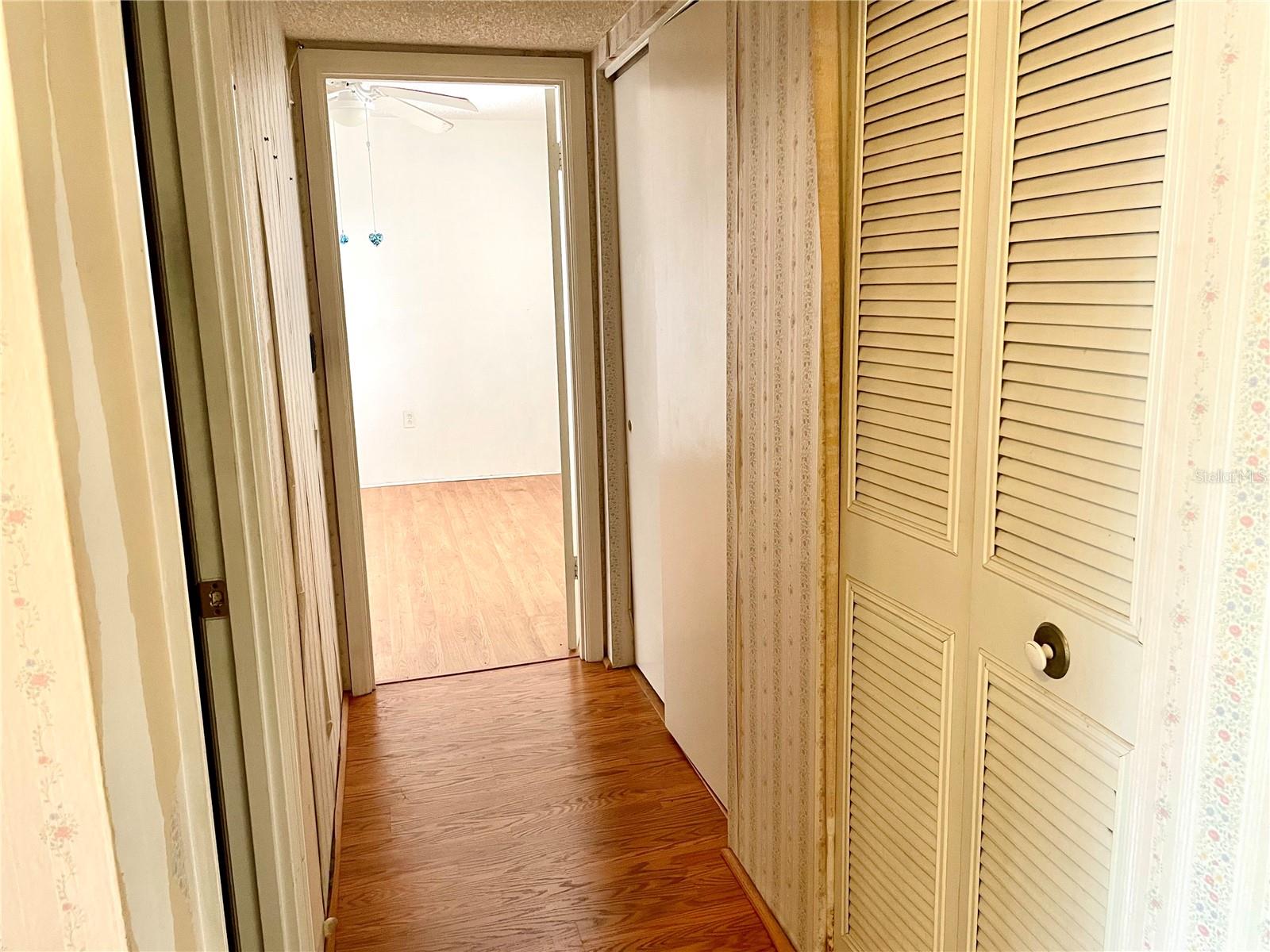 Hallway to 2nd bedroom, with 2 storage closets