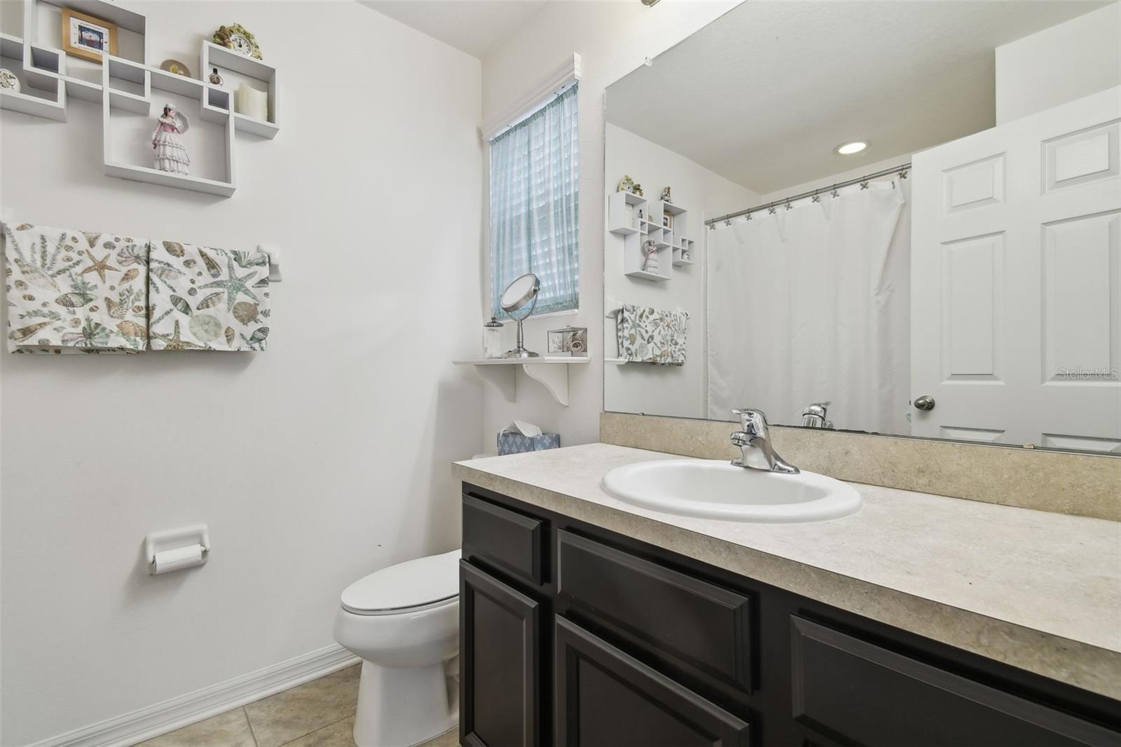 Master ensuite with single vanity and tub with shower.