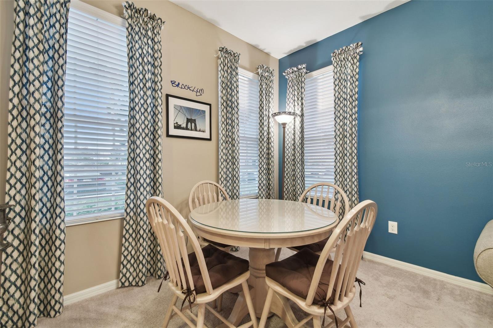 Dining area view.  Rods and custom fitted drapes will remain.