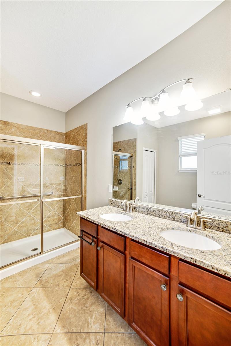 SHOWER IS A GOOD SIZE AND FEATURES GLASS DOORS