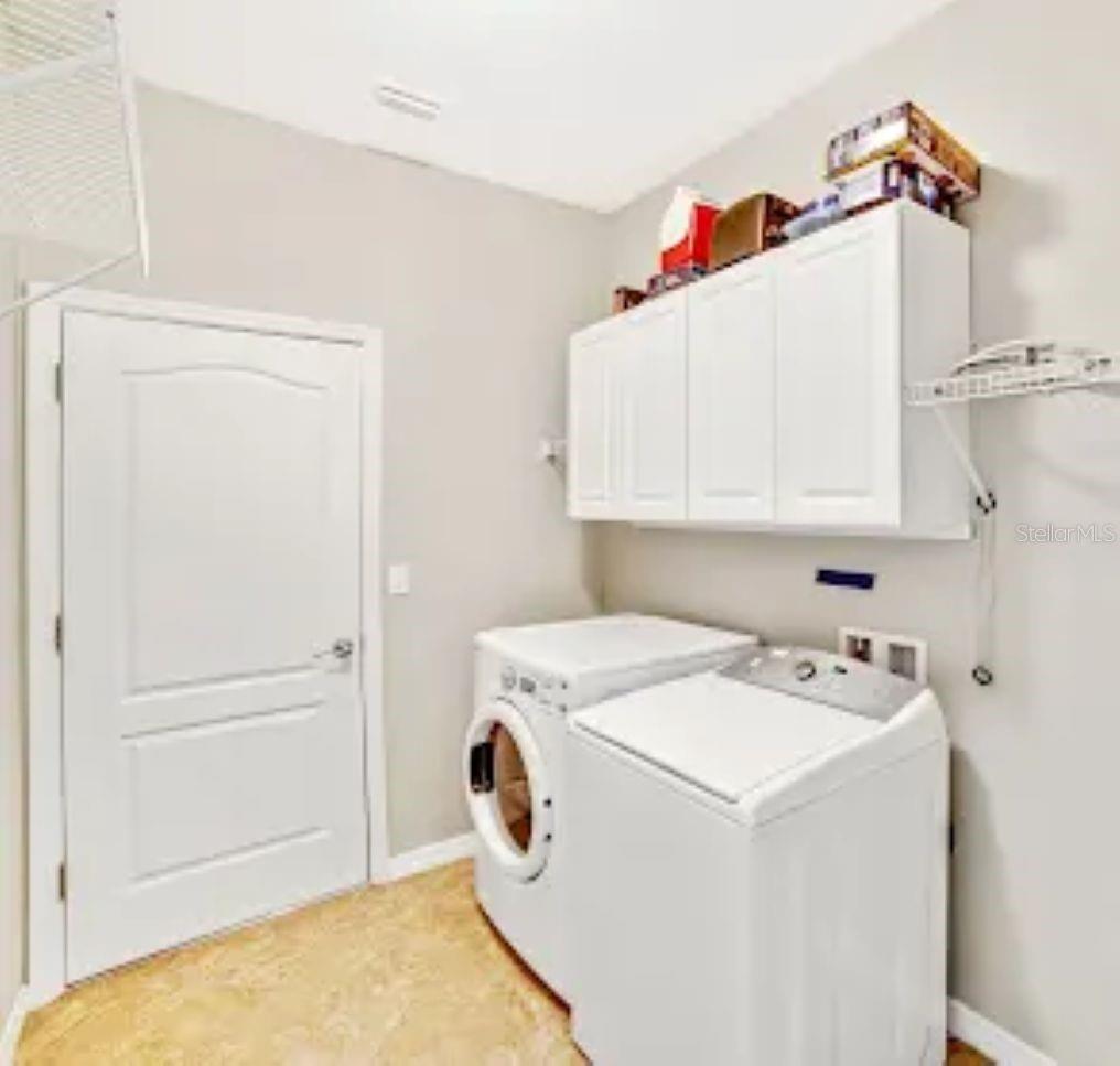 LAUNDRY ROOM WITH STORAGE CABINETS, WASHER AND DRYER