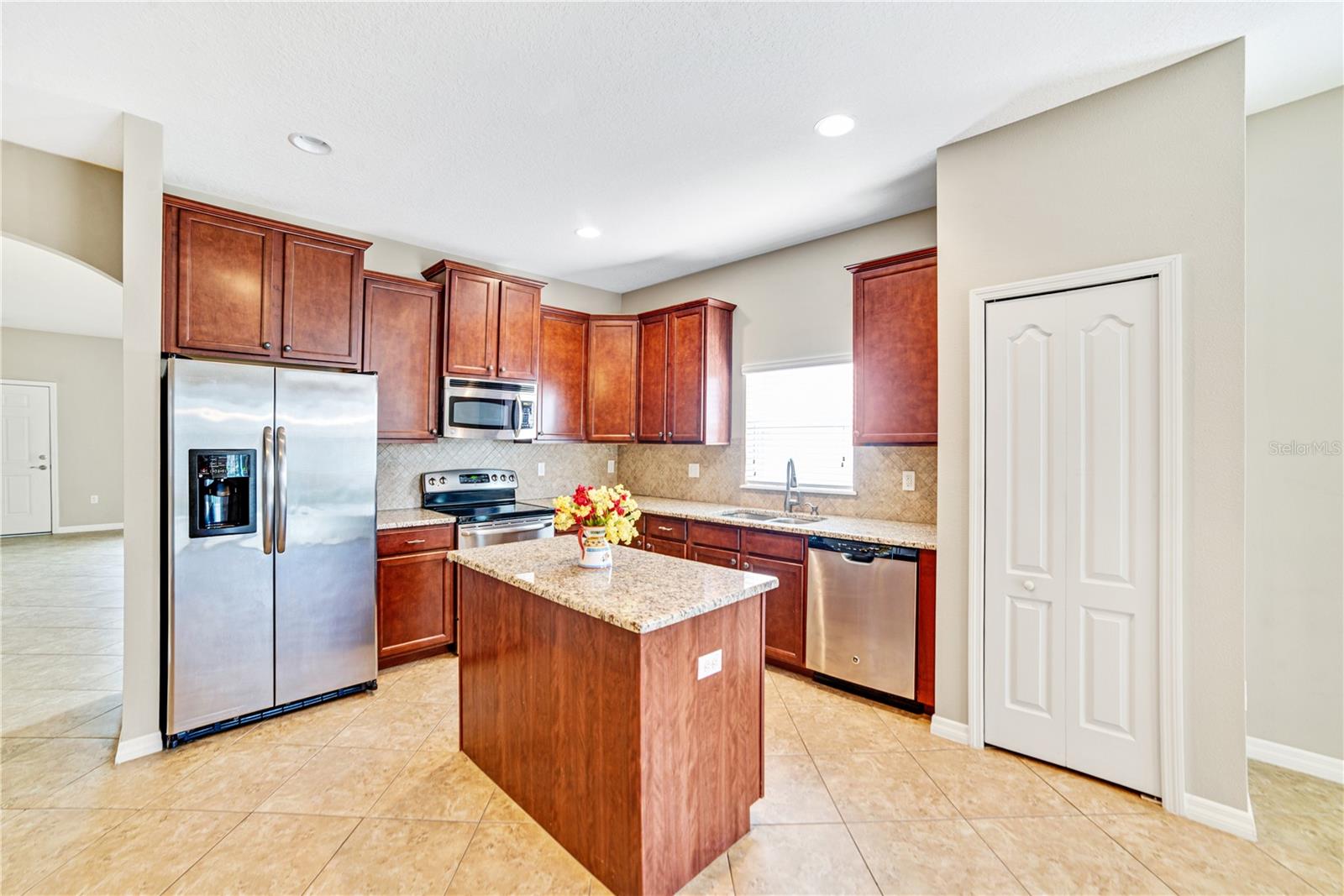 BEAUTIFULLY APPOINTED KITCHEN FEATURES OVER THE SINK WINDOW AND PANTRY