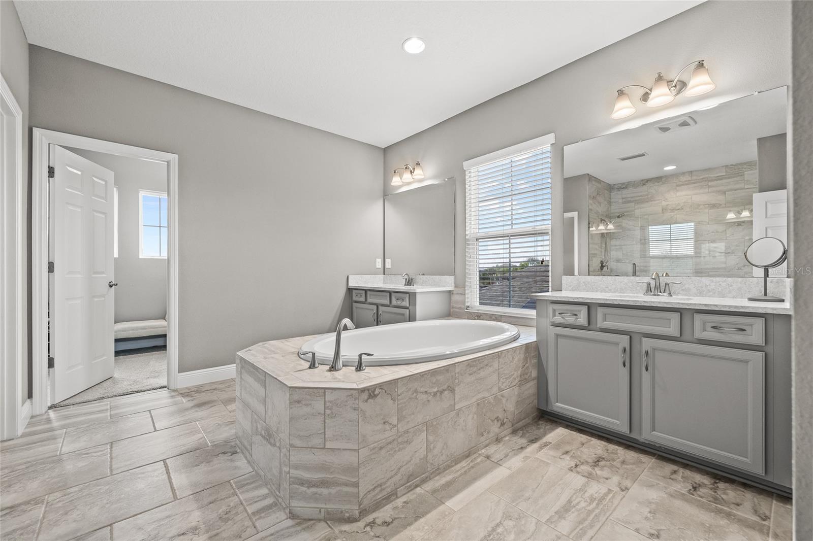 En-suite primary bath with dual vanities and soaking tub. Access to large walk-n closet