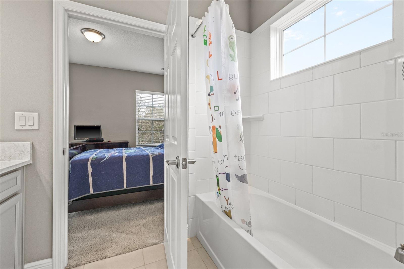 Full Jack and Jill bathroom with dual vanities and tub shower