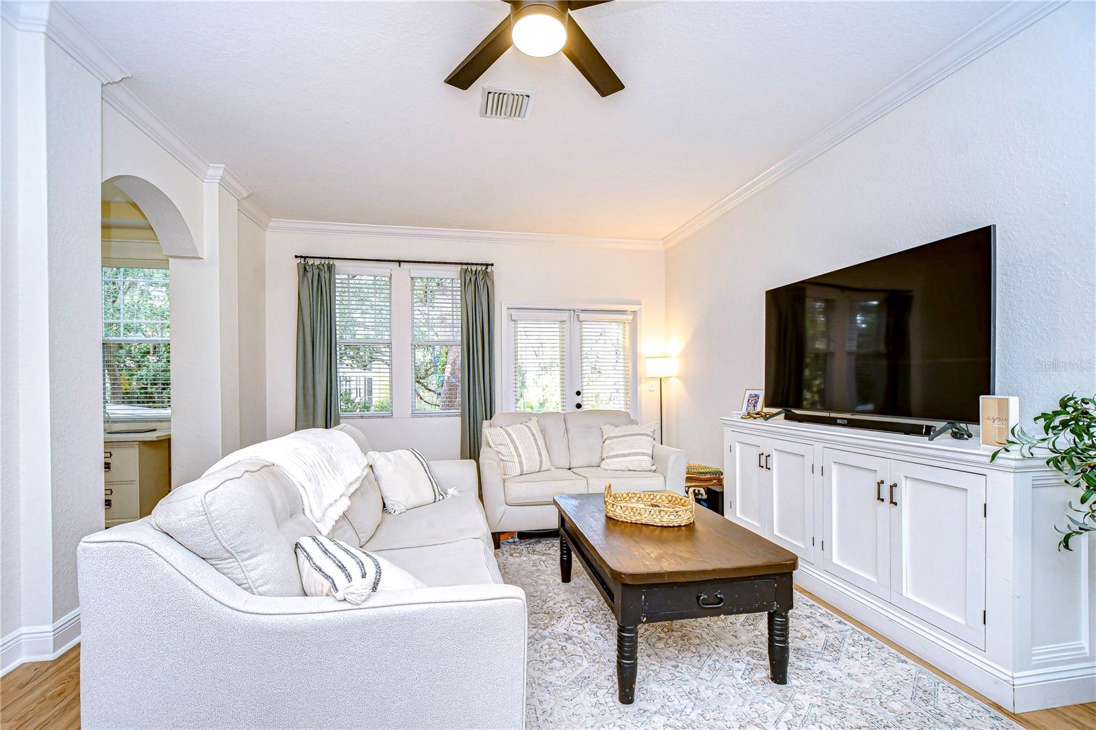 Living room with French doors and windows providing ample light and beautiful views of the mature oak trees!