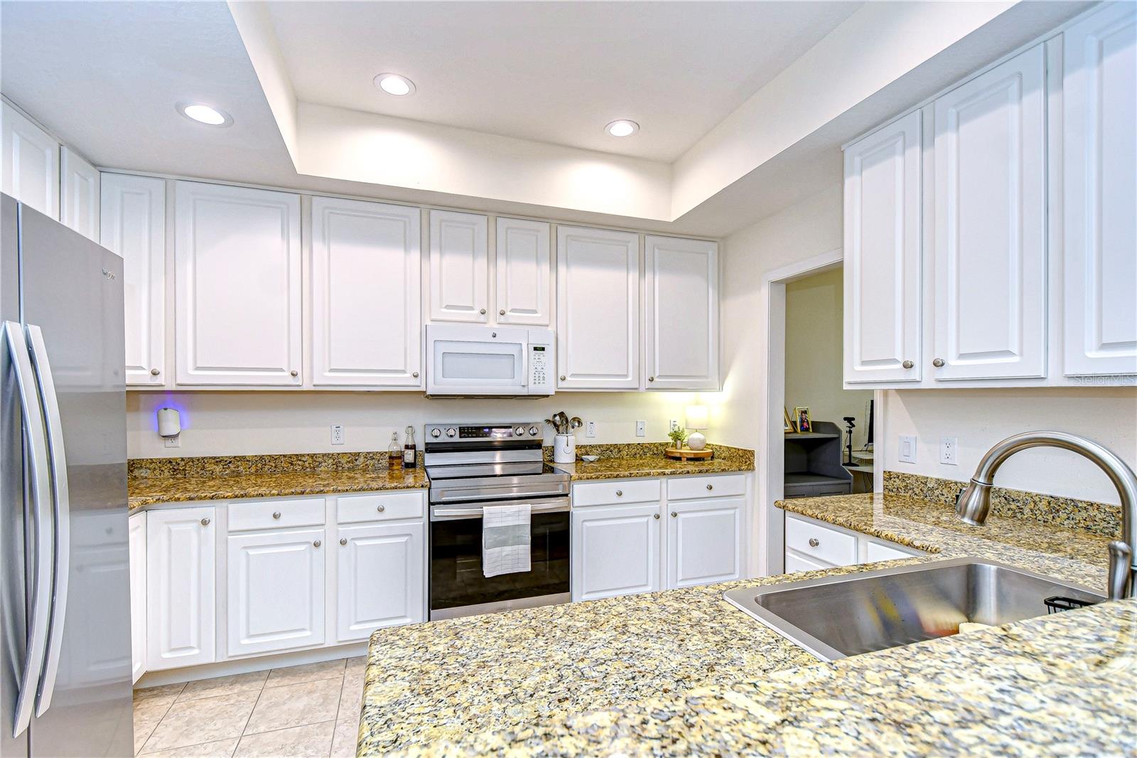 Large kitchen features recessed lighting, and a trayed ceiling!