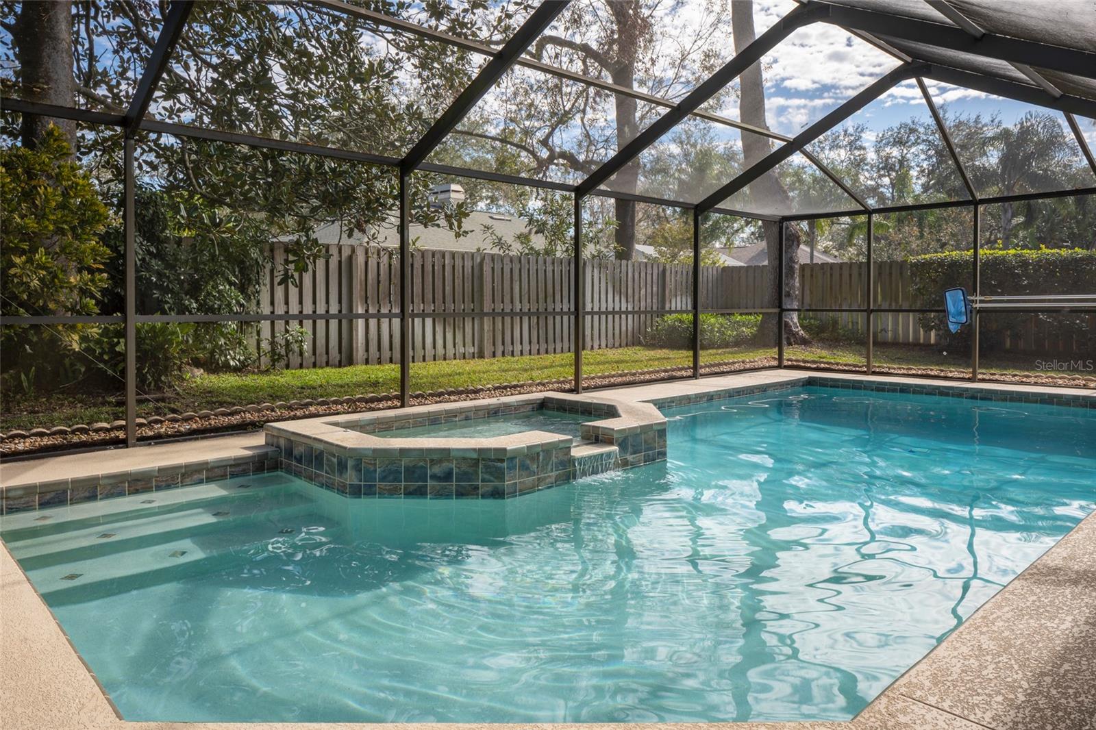 Fenced back yard beyond pool