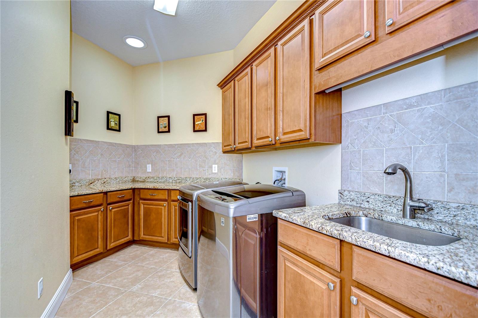 EXPANSIVE laundry room with so much counter space and lots of cabinets!