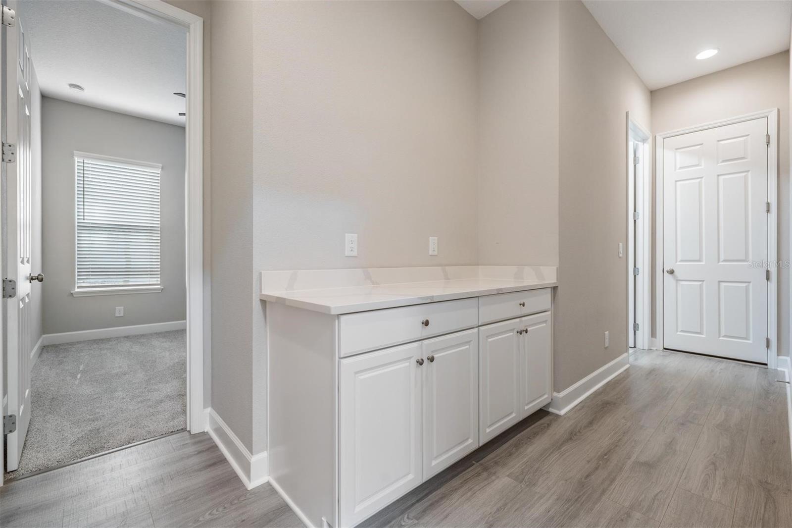 Downstairs hall with built-in drop zone, leading from 2 car garage, and laundry room