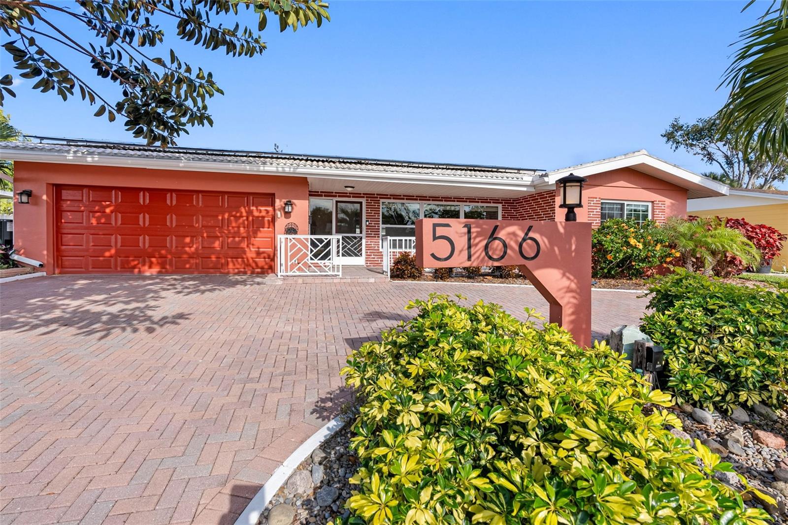 1.Welcome Home: Stunning Mid-Century Modern charm with a stately rubber tree, circular paver driveway, and vibrant hibiscus in Maximo Moorings.