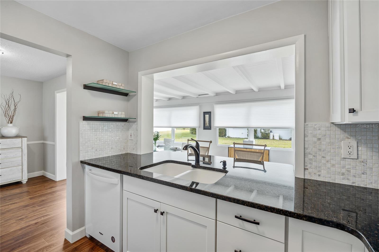 The kitchen features a pass-through breakfast bar that opens to the sunroom, creating a bright and inviting space.