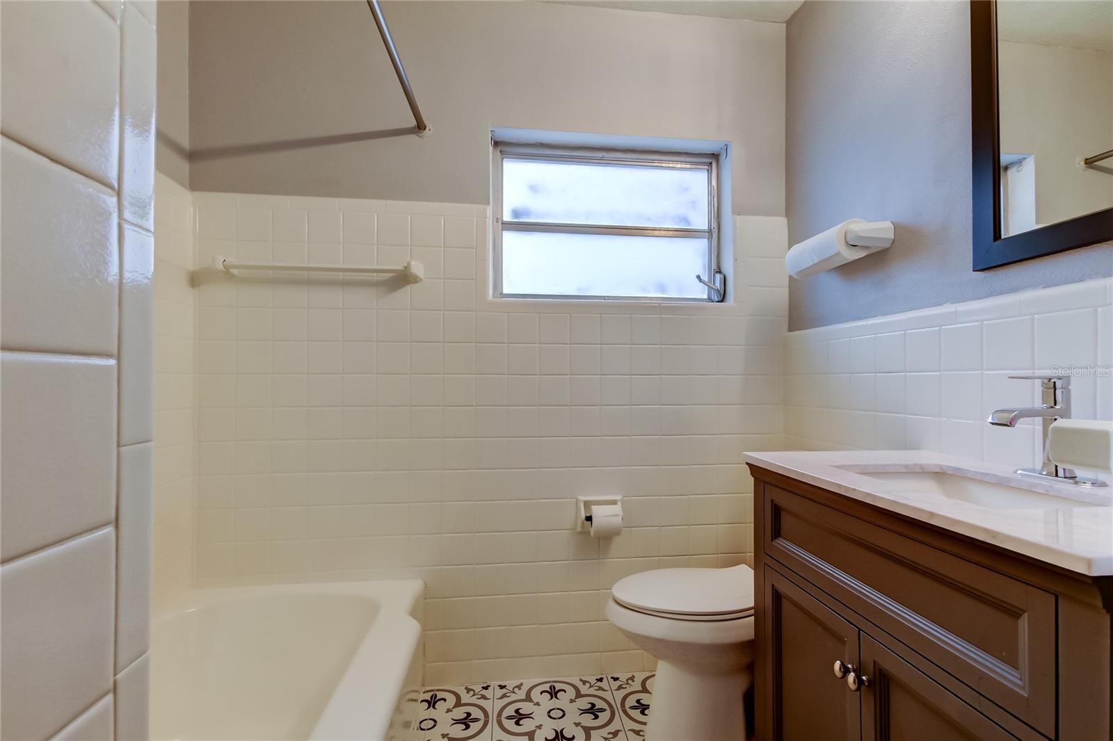 Guest Bath has newer vanity, tub with shower head, and separate shower.