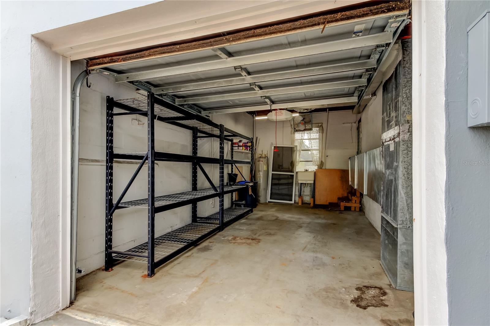 Single Car Garage has shelving, sink, water heater, garage door opener, and air handler.