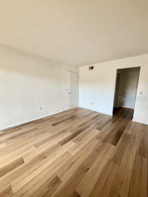 Bedroom with beautiful flooring & entrance to closet area & bath