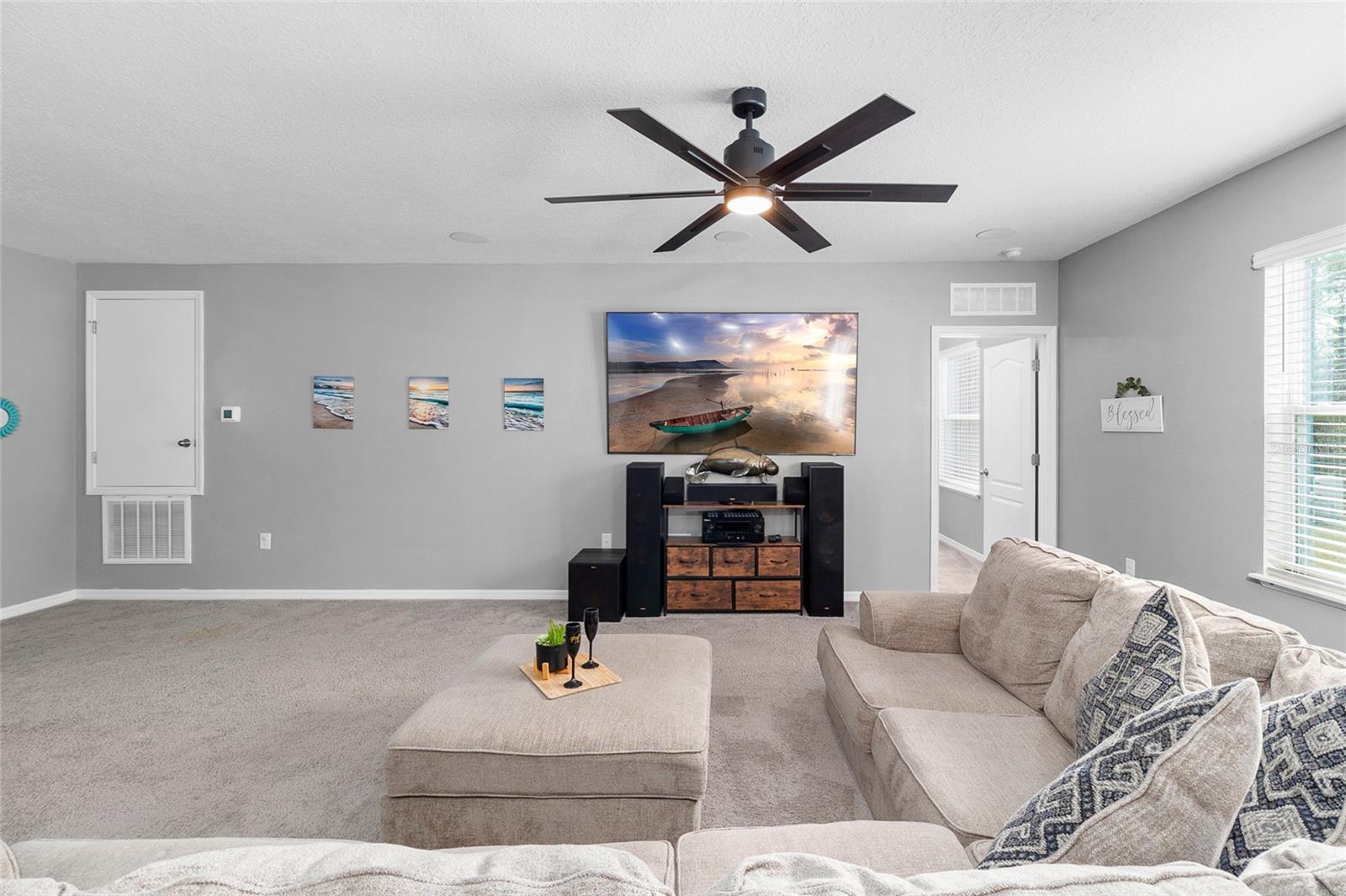 spacious tv room with huge fan that makes a great enterrainment area