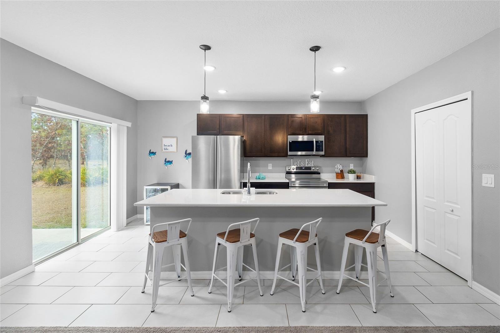 Gorgeous kitchen with gorgeous Quartz countertops, stainless  steel appliances, eat-in bar