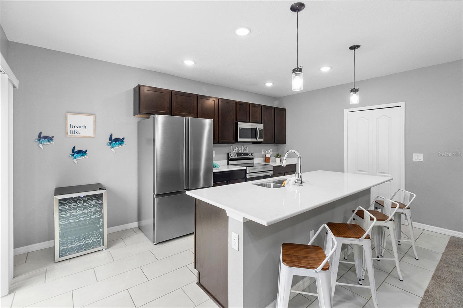 Gorgeous kitchen with gorgeous Quartz countertops, stainless  steel appliances, reach-in pantry