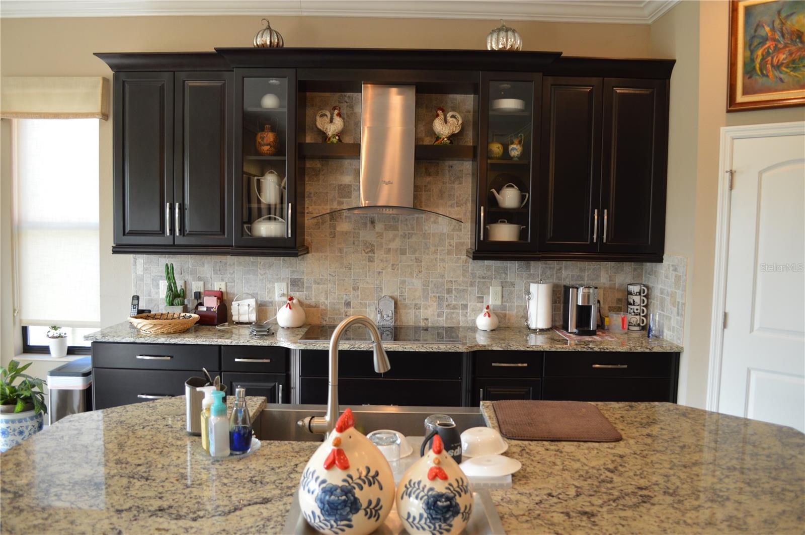 Side kitchen view.  Top of the counter stove and stainless-steel exhaust.