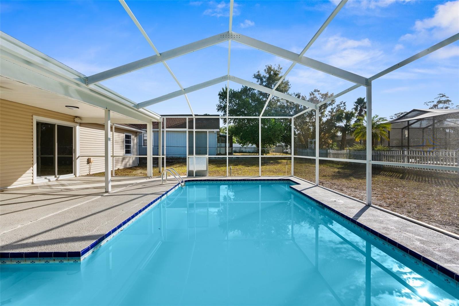 In-ground pool with screen enclosure.