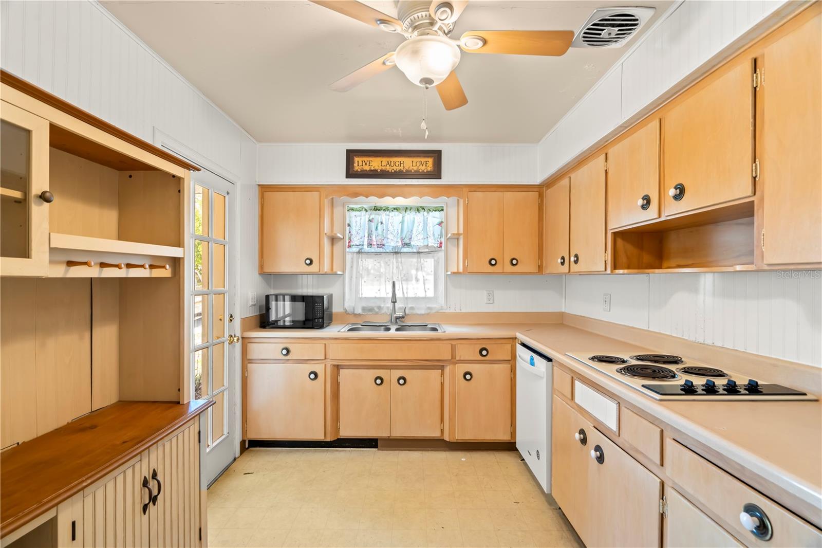 Cute vintage retro kitchen! Includes a side-by-side fridge with water & ice dispenser, dishwasher, built-in oven and cooktop stove. Also includes a coffee bar hutch, ceiling fan and single french door that opens to the front porch.