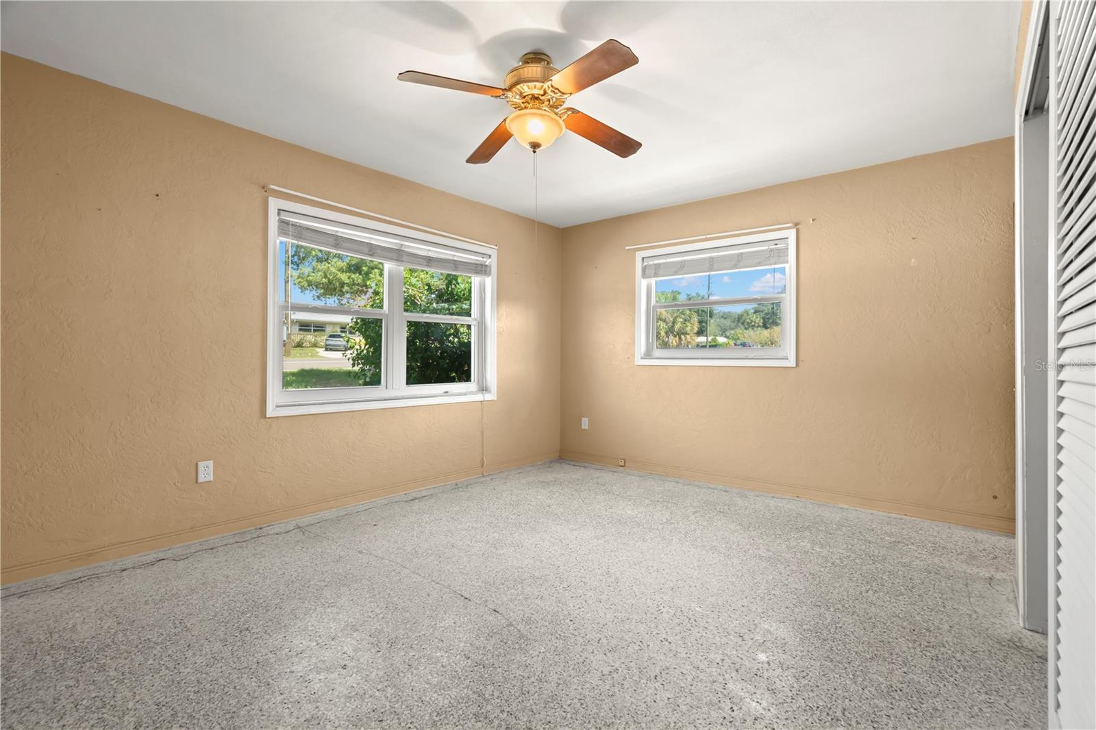 Master Bedroom has ceiling fan and an En Suite bathroom. Check out those new windows throughout the house! Carpets have been ripped up so you can install your own flooring or leave the terrazzo underneath