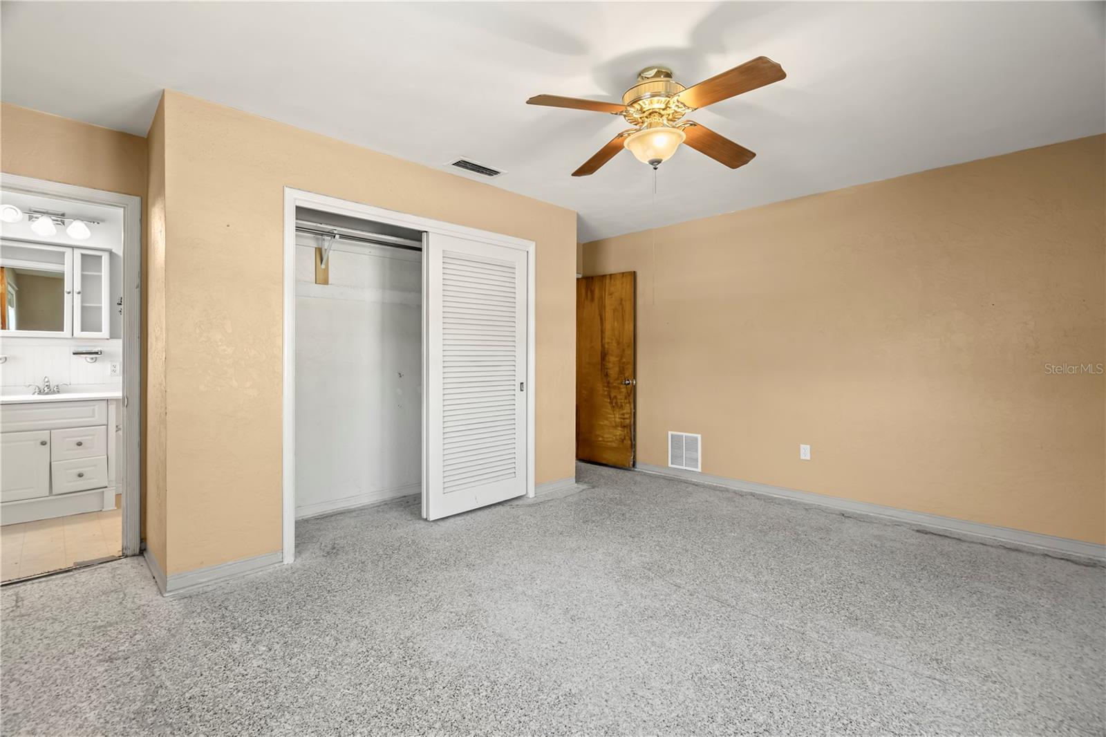 Master Bedroom with ceiling fan and updated En Suite bath.Carpets have been ripped up so you can install your own flooring or leave the terrazzo underneath.