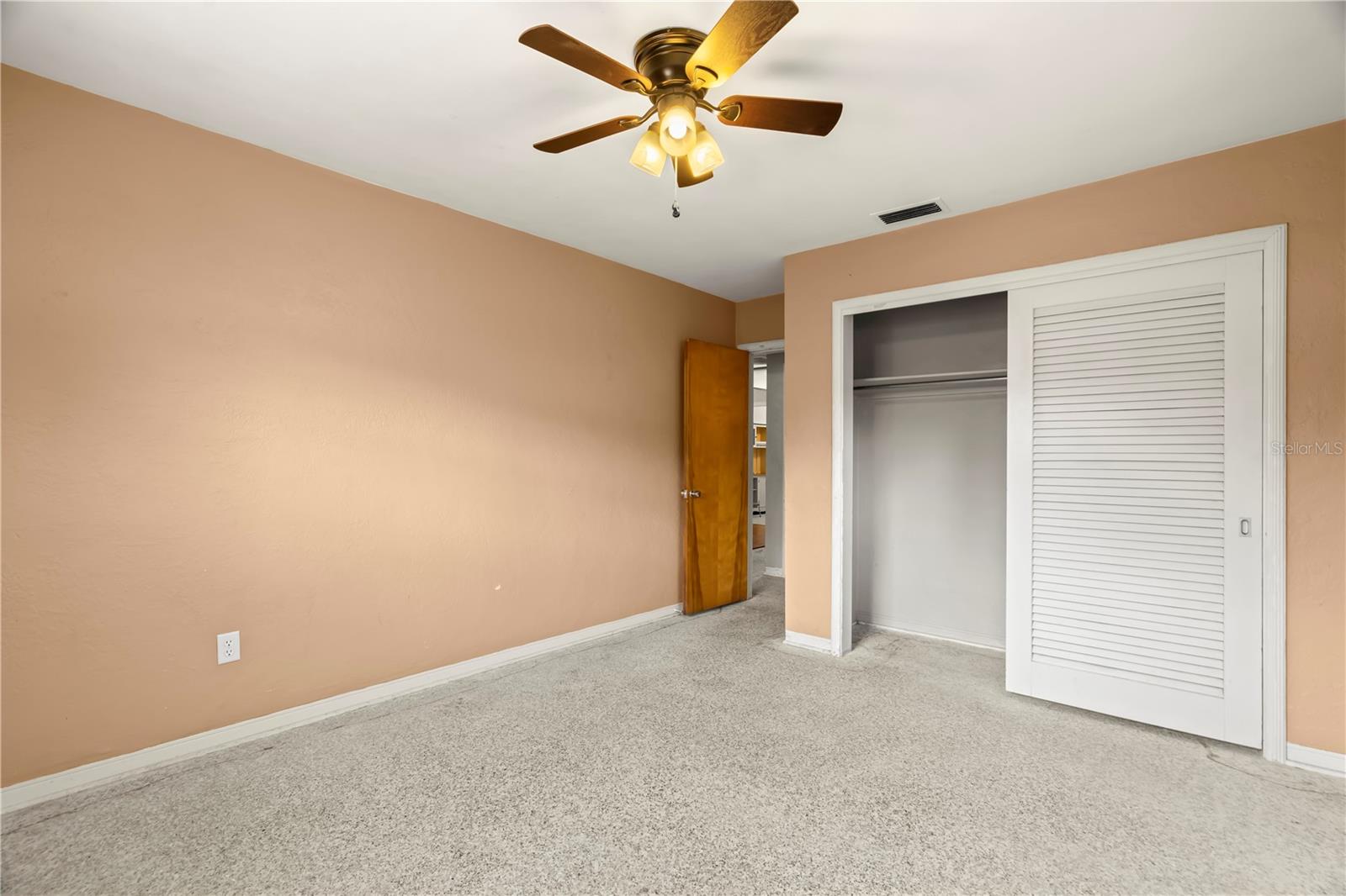 2nd bedroom with ceiling fan.Carpets have been ripped up so you can install your own flooring or leave the terrazzo underneath.