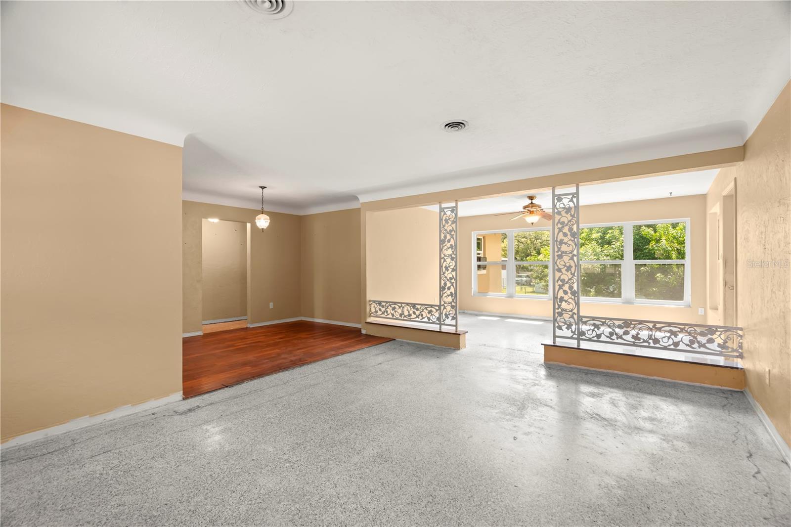 Living Room with elegant COVED CEILINGS! Carpets have been ripped up so you can install your own flooring or keep the terrazzo underneath