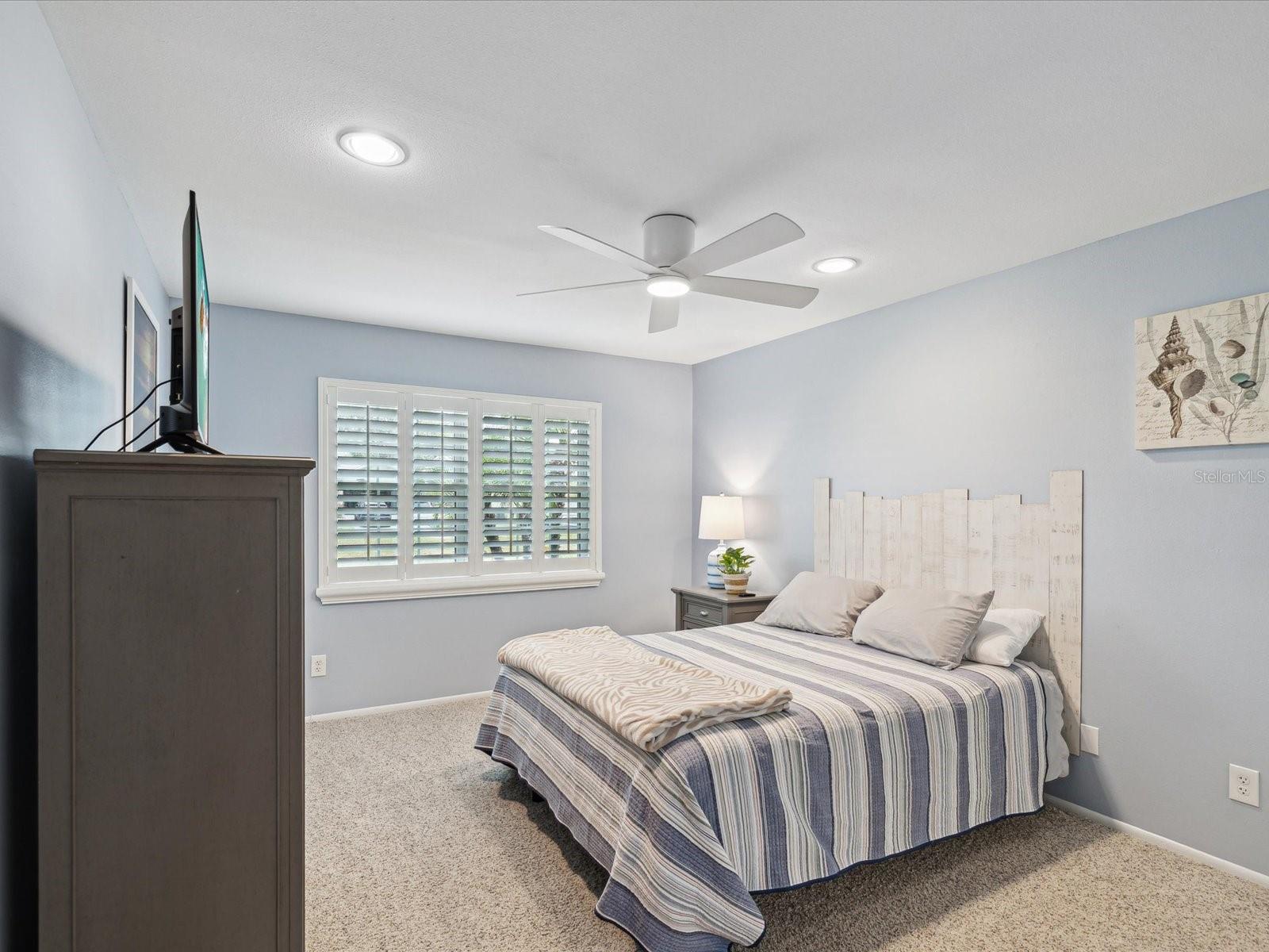 Guest Bedroom with 3 1/2 wood shutters and recessed lighting