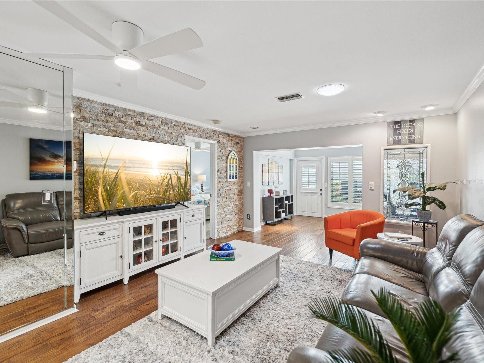 Living Room with Flagstone wall, crown molding and beautiful clean flooring