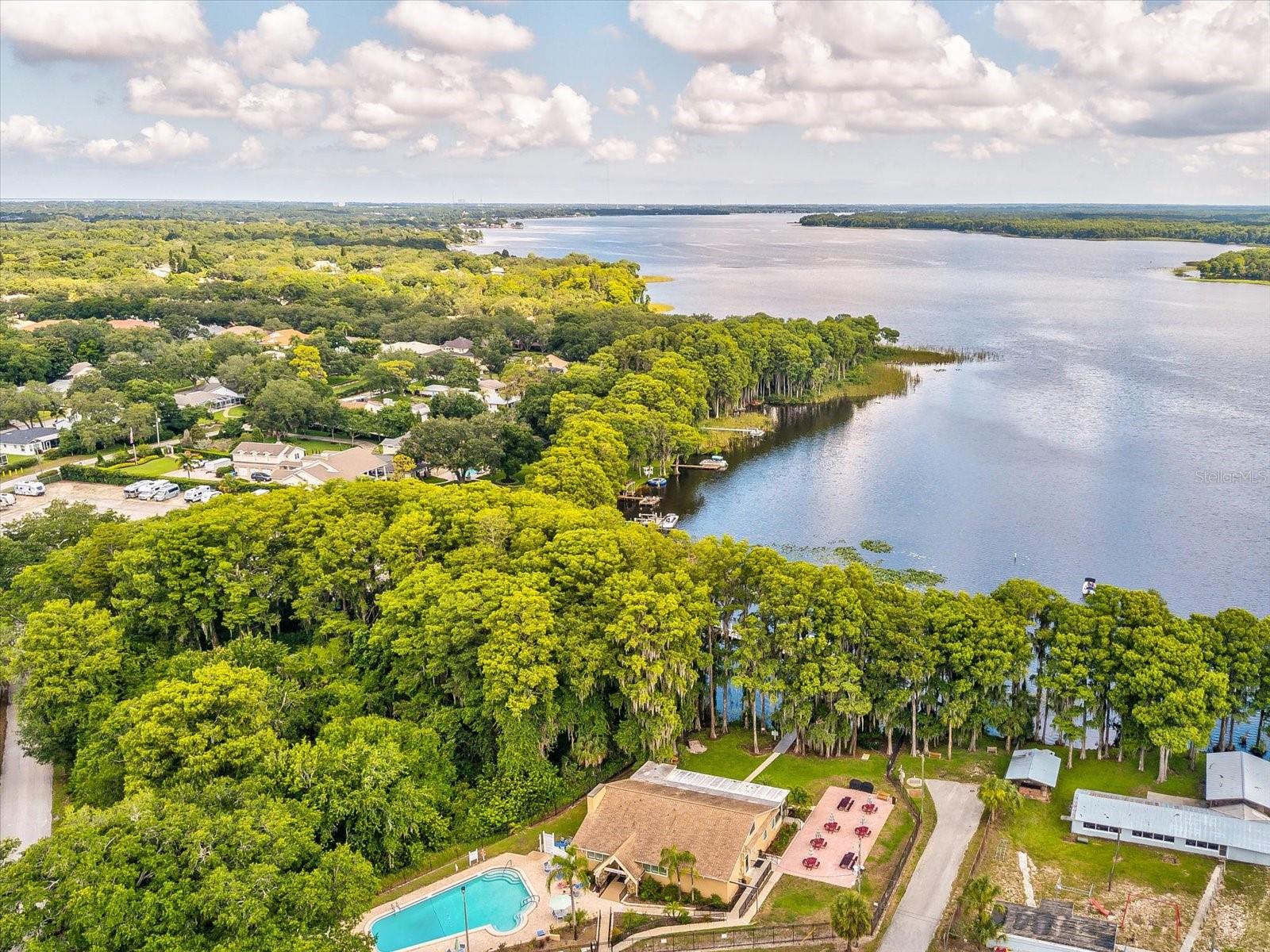 The “rustic” Lodge features a large multi-purpose room with beautiful hardwood floors, stone fireplace and a service kitchen. Huge windows in the enclosed porch frame a panoramic view of Lake Tarpon and two pontoon boats to tour the lake.