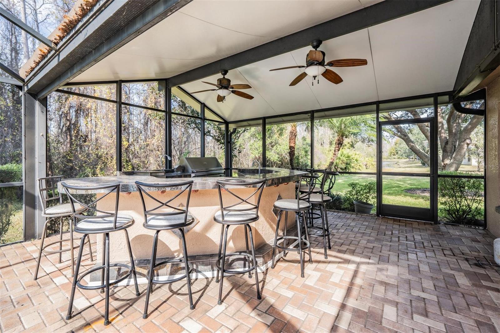 Outdoor kitchen with custom bar and conservation views