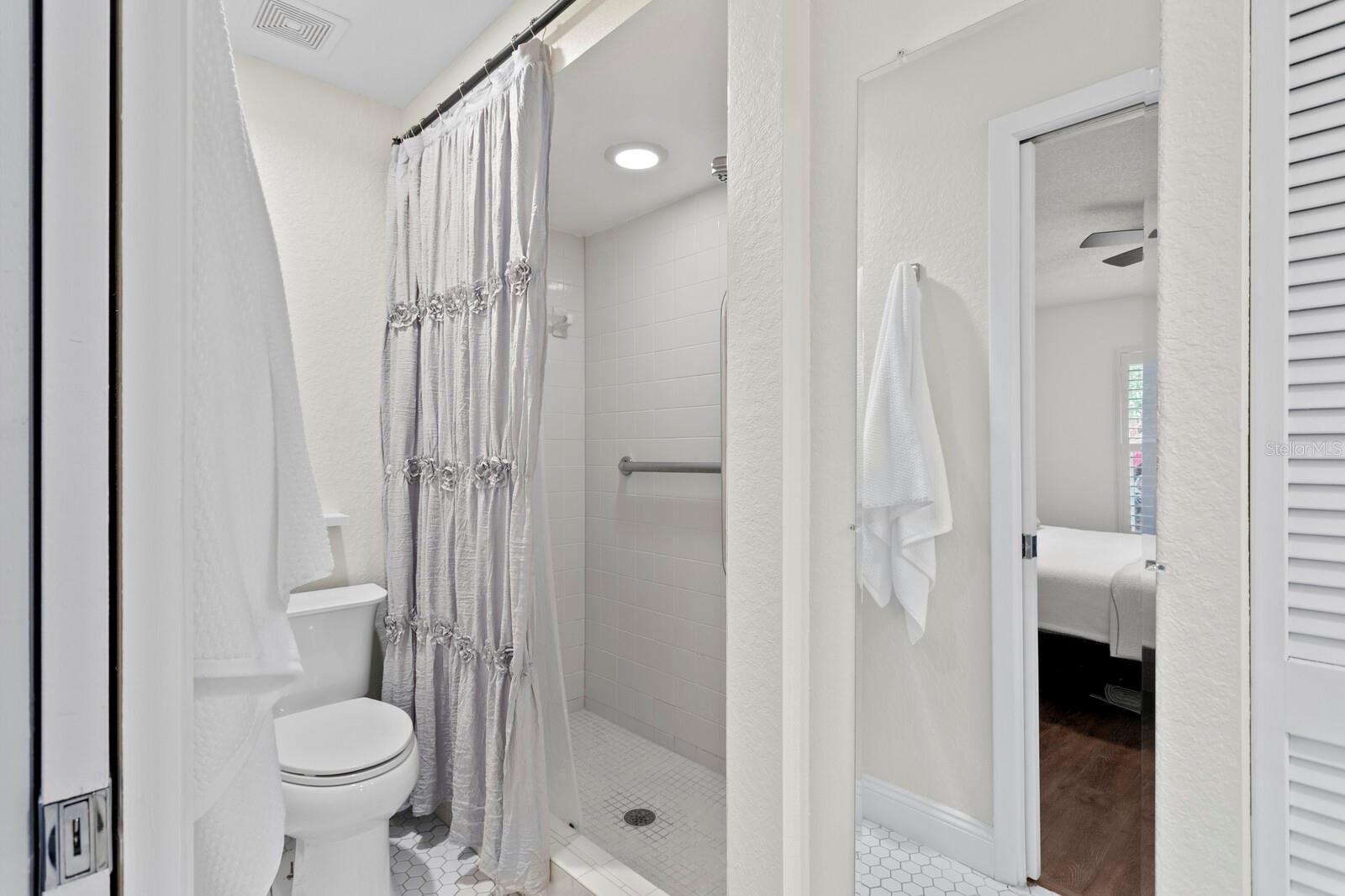 Primary bath with walk-in shower and walk-in closet with custom organizer