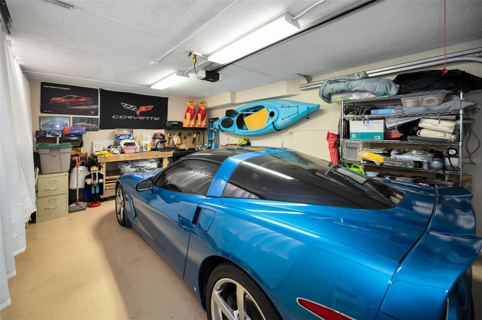OVERSIZED 1 CAR GARAGE WITH EXTRA STORAGE SHELVING BEHIND THE CURTAIN