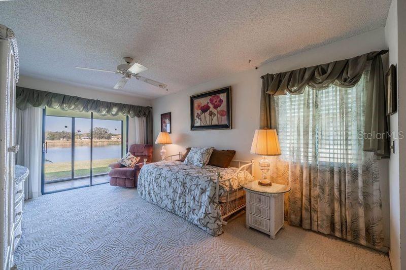 Guest bedroom with water view and sliders out to lanai