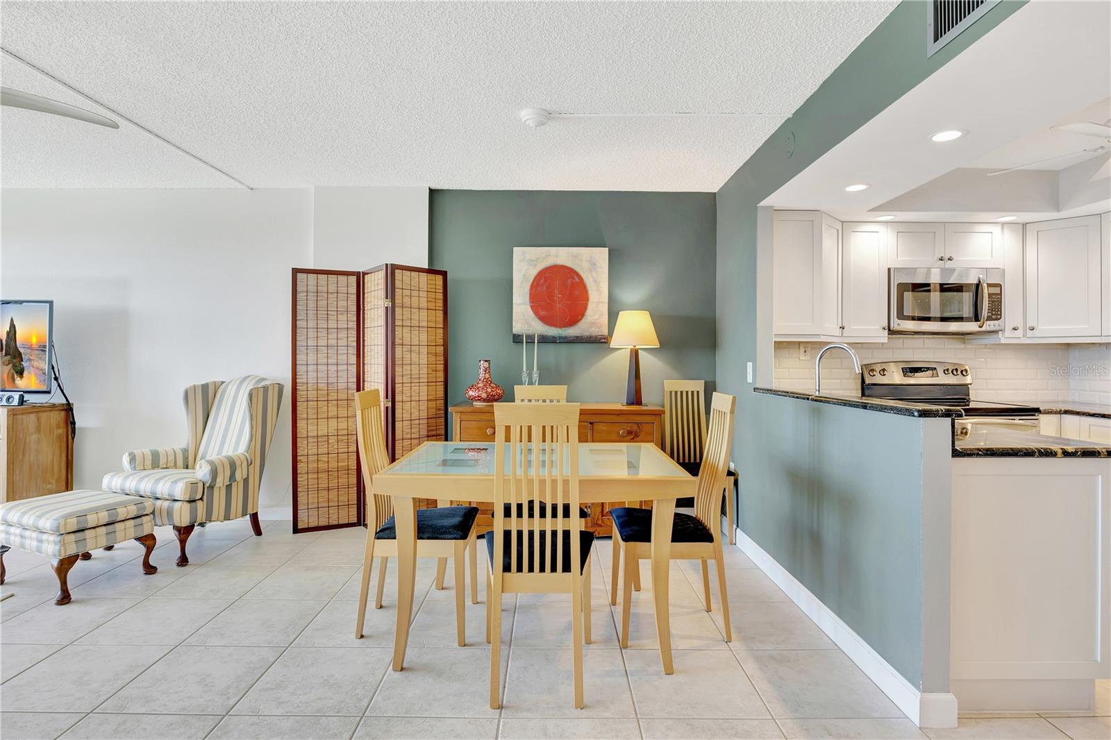 The kitchen is open the living area and has counter seating .