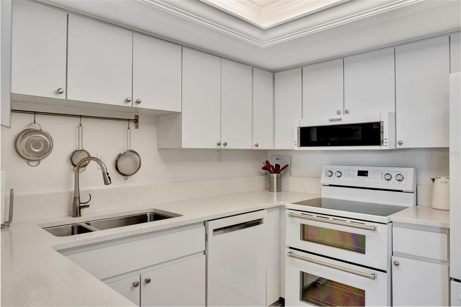 Another kitchen view showing spacious cabinet, a double sink and double oven