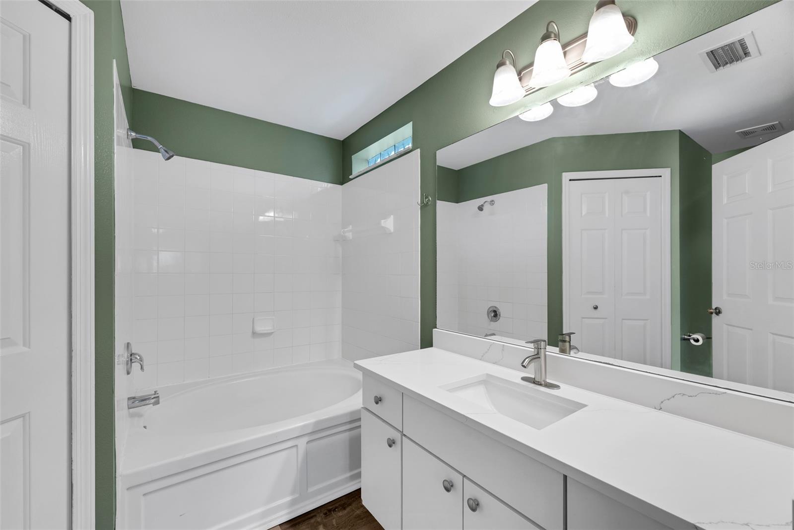 The primary bath retreat offers a relaxing garden tub/shower combination, spacious vanity with updated granite and fixtures and access to a walk-in closet.