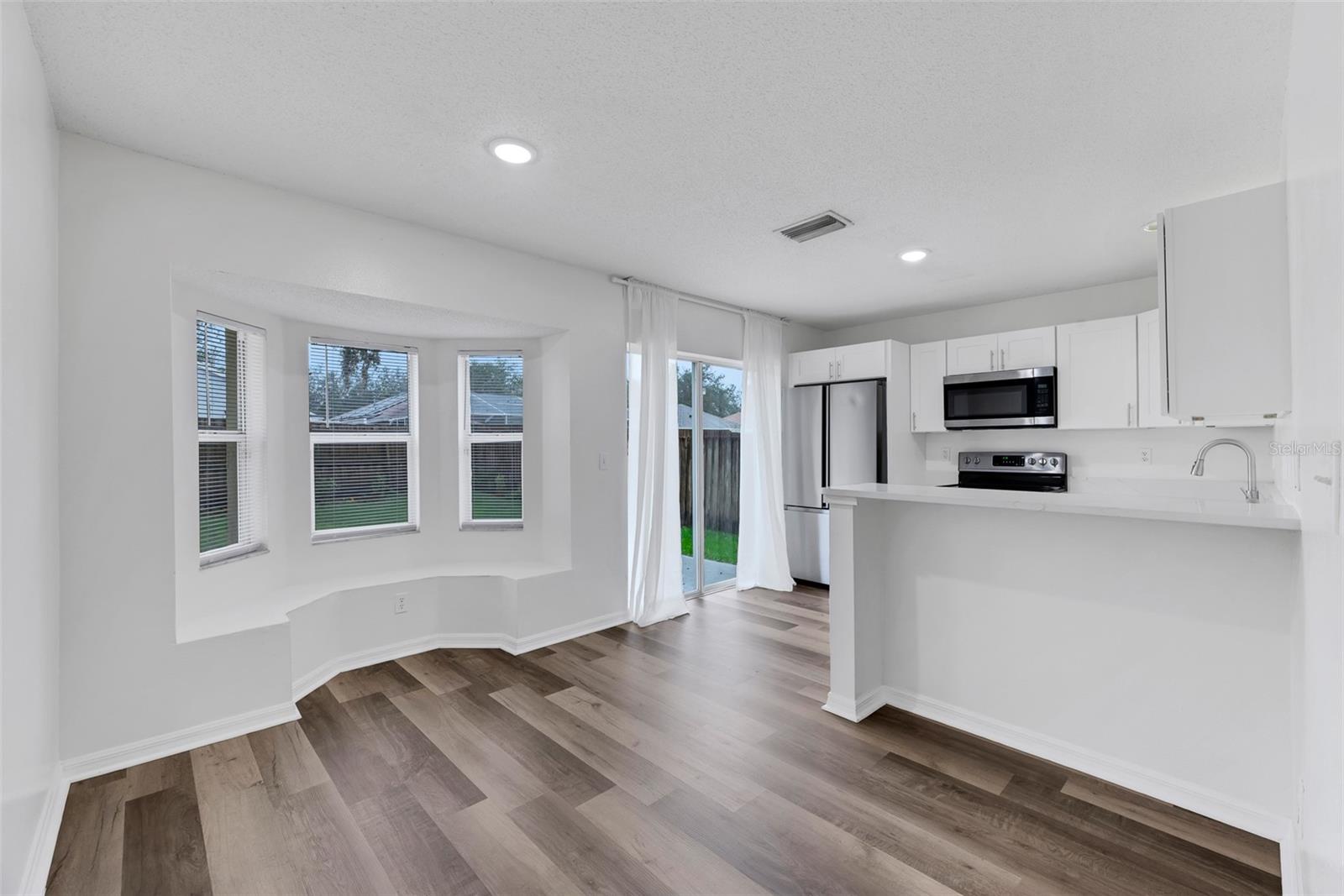 A charming and cozy bay window with built-in garden seats is the perfect place for a dining table with additional seating at the breakfast bar.