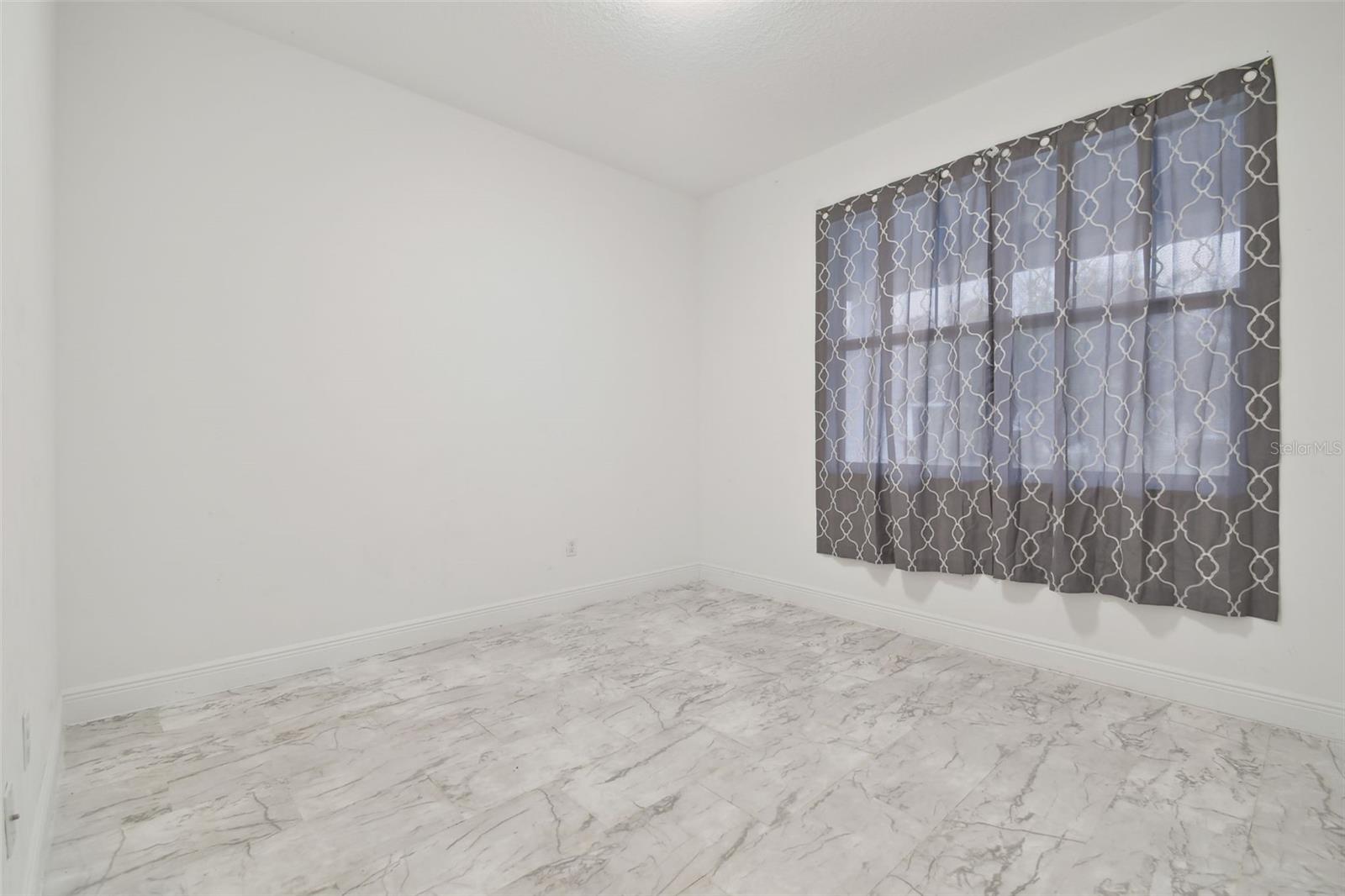 Bedroom 2 at the front of the home, with updated vinyl flooring.