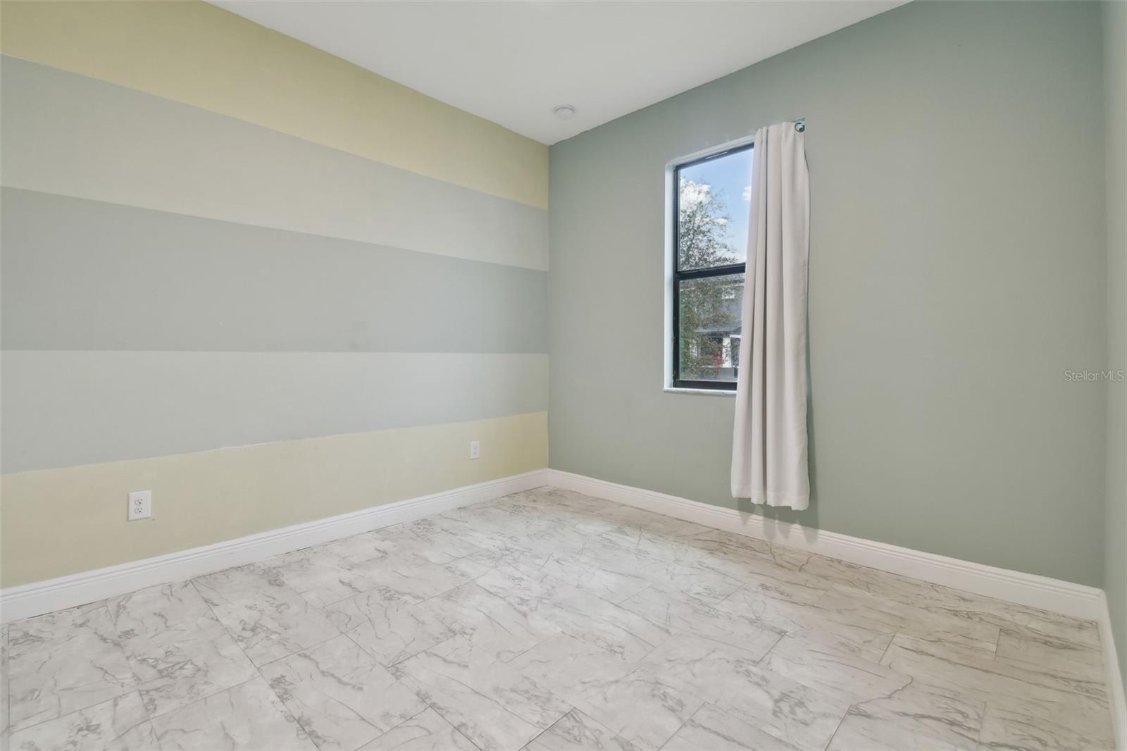 Bedroom 3 with vinyl flooring and views to the side of the home.