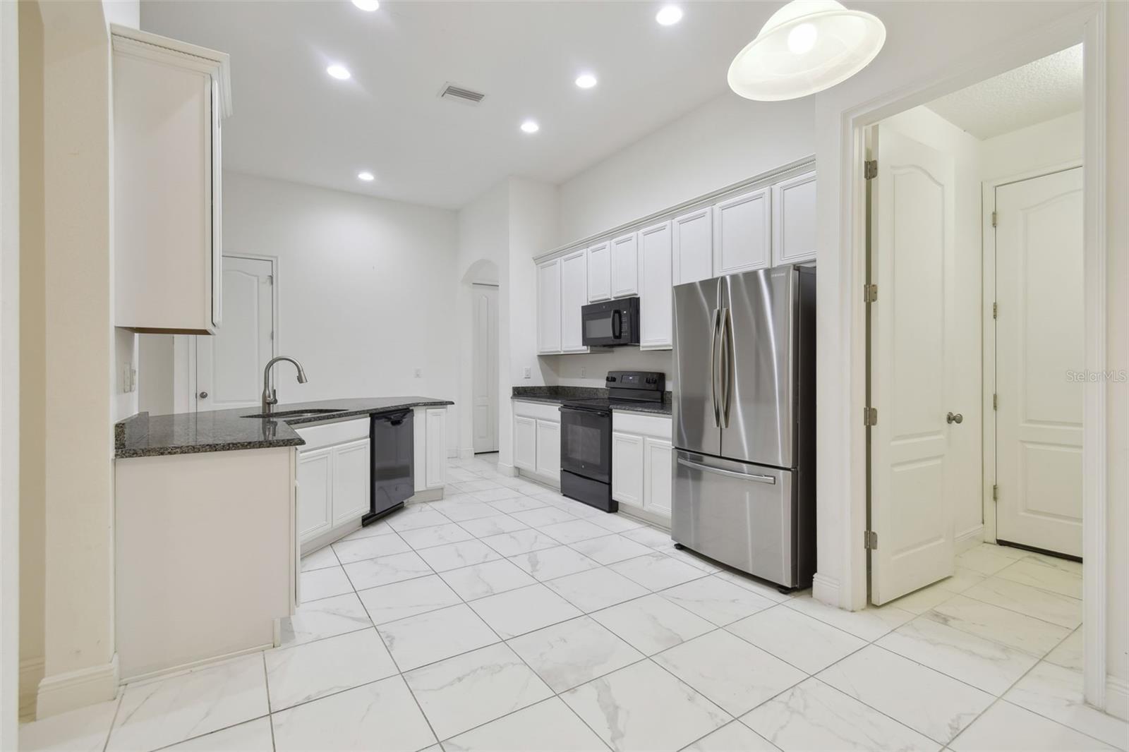 View from breakfast nook towards the kitchen. Door to the right is the inside laundry and access out to the garage.