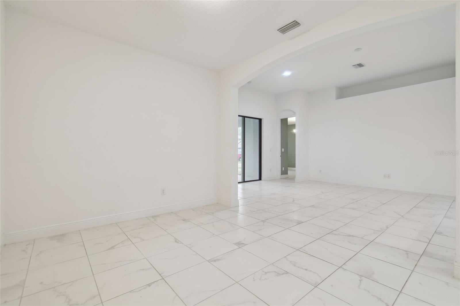 View from dining area towards the living area with beautiful porcelain tiled floors.