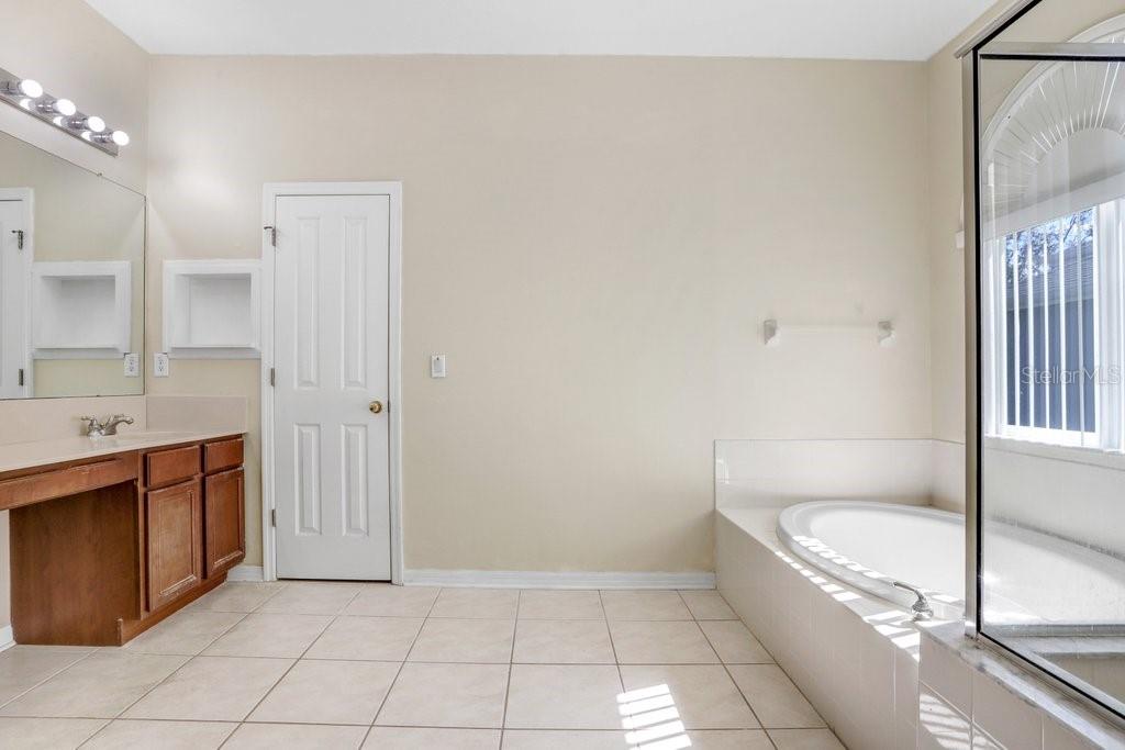 Primary Bathroom with dual sink vanity, garden tub and walk in shower