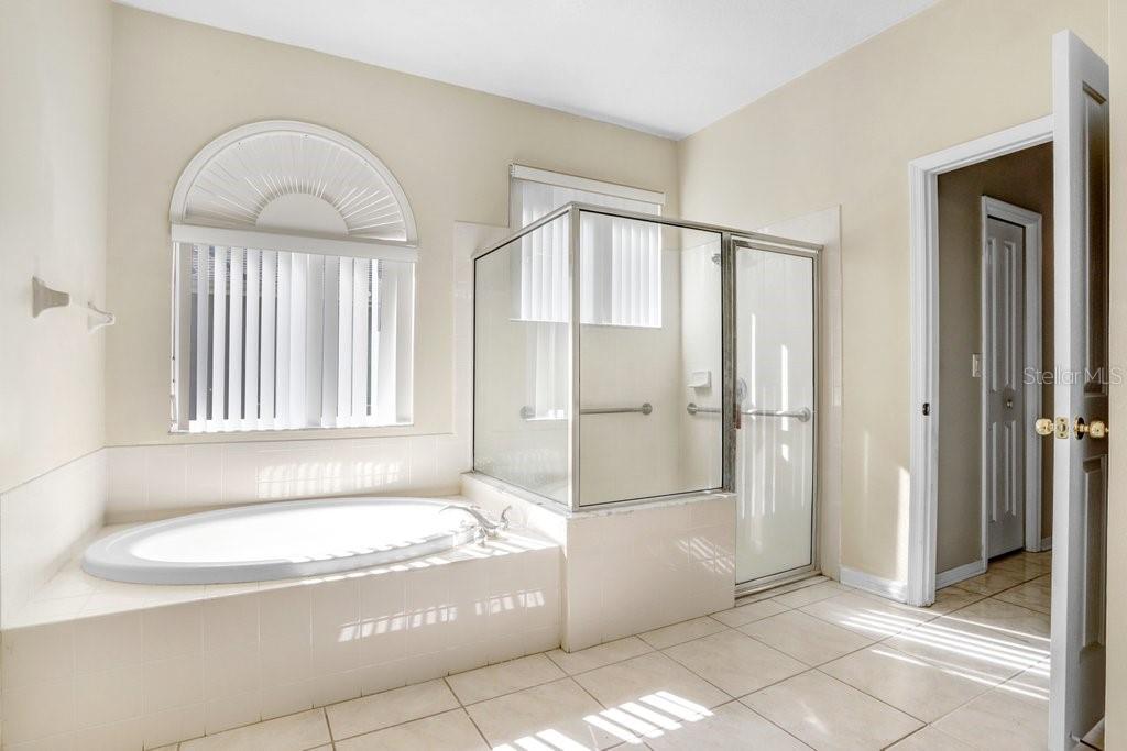 Primary Bathroom with dual sink vanity, garden tub and walk in shower