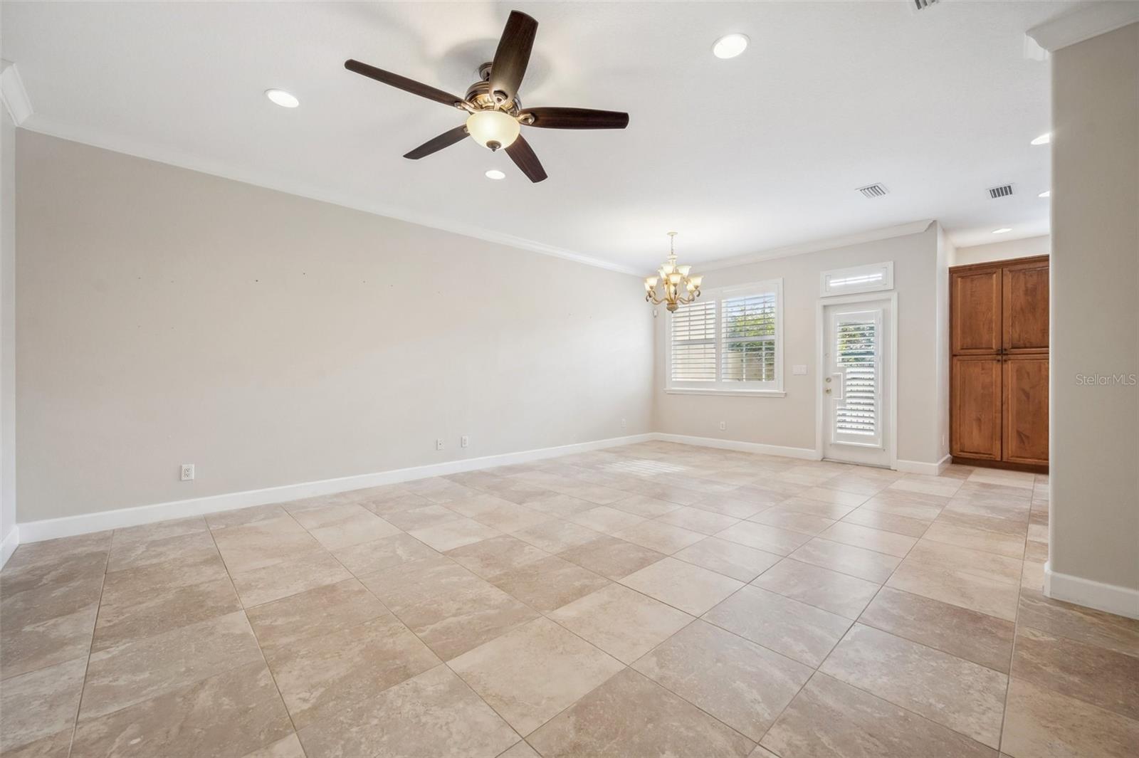 Large, tiled Dining Room/Living Room layout with door (right) to the back courtyard.