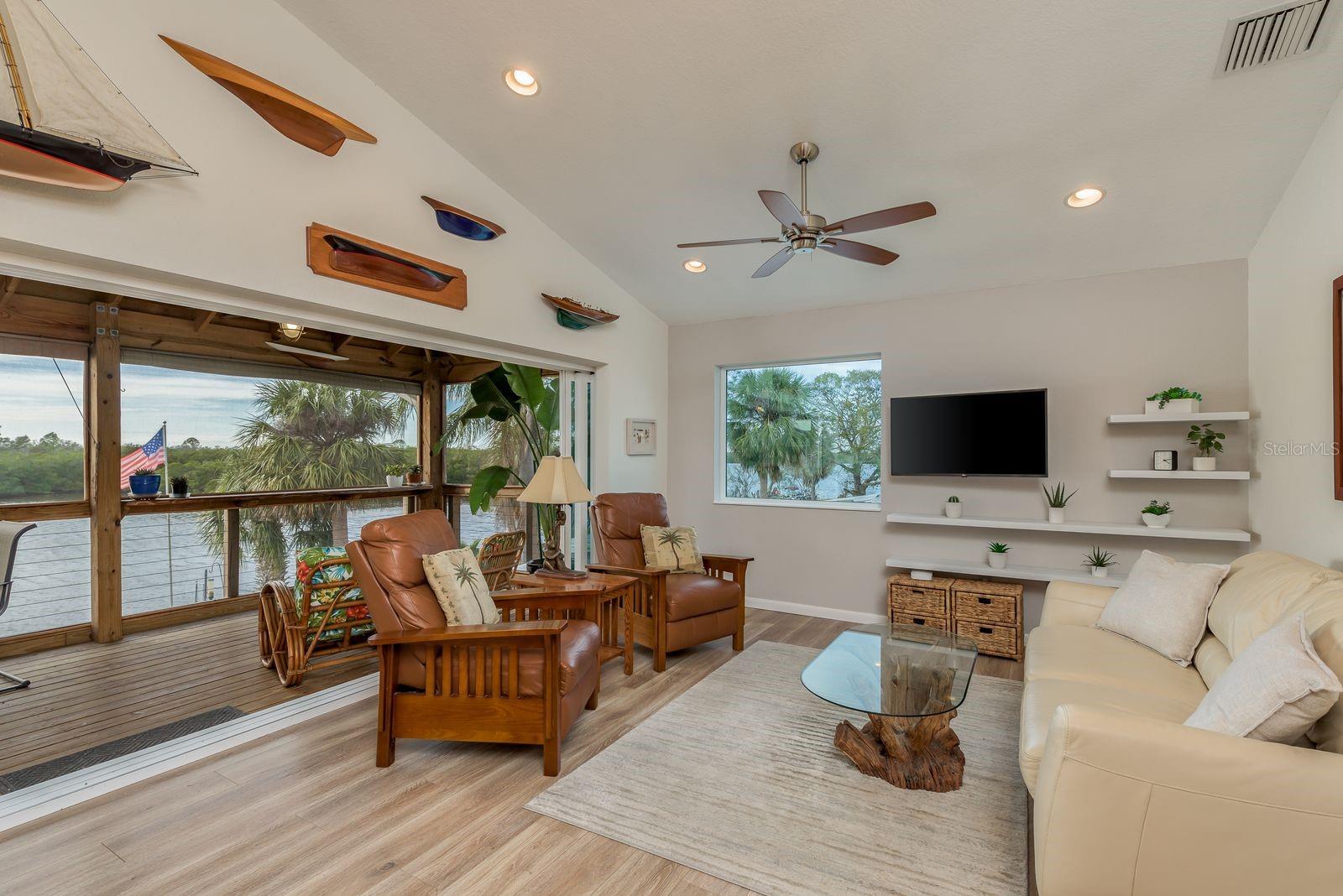 6 glass pane doors open up to screened patio for panoramic water view