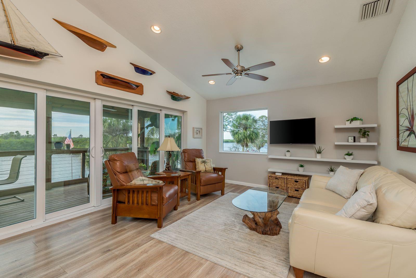 6 glass pane doors open up to screened patio for panoramic water view