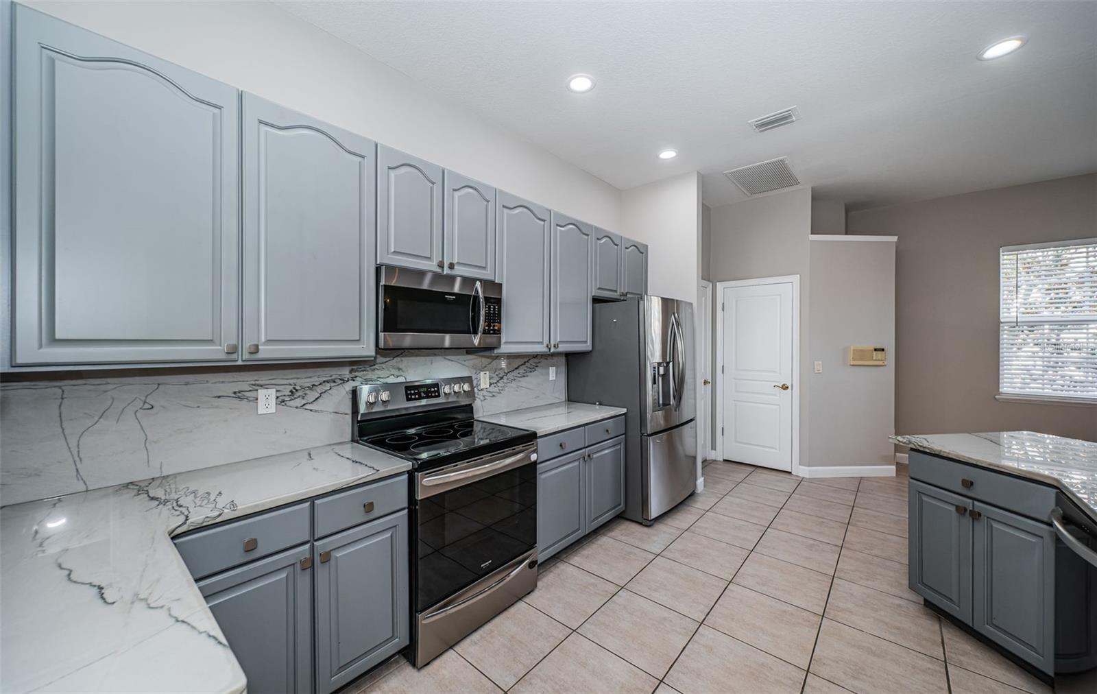 Beautiful kitchen with stone countertops, ss appliances and walk-in pantry.